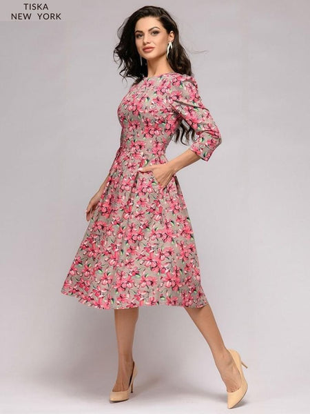 Model with A-Line, crewneck, knee length vintage cocktail dress. Pink Floral Printed dress sideways